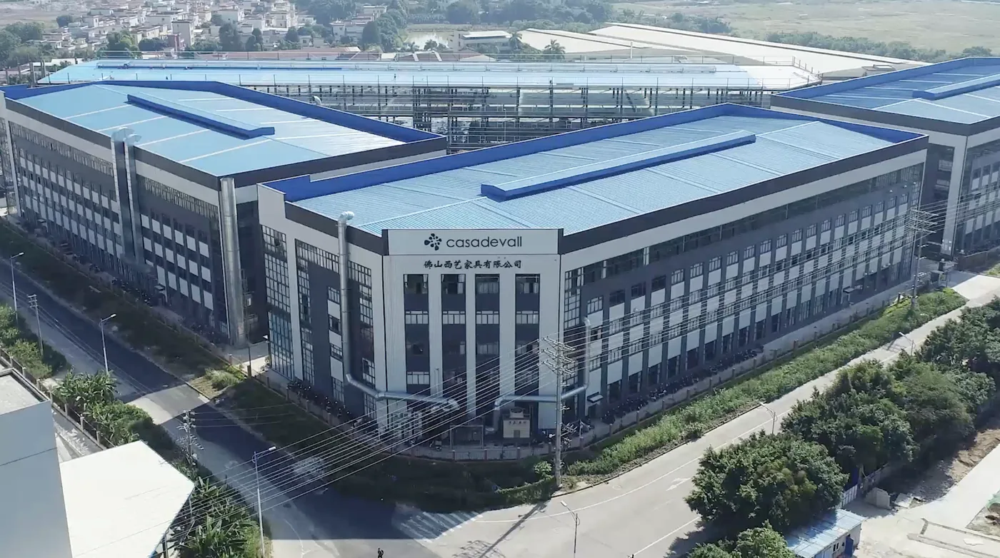 The Casadevall China plant in Foshan seen from the air - blue-roofed halls around a five-storey block.