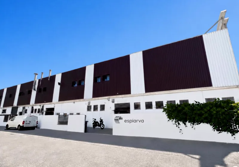 The Casadevall Espiarva metalwork factory, a long production hall under a clear sky.